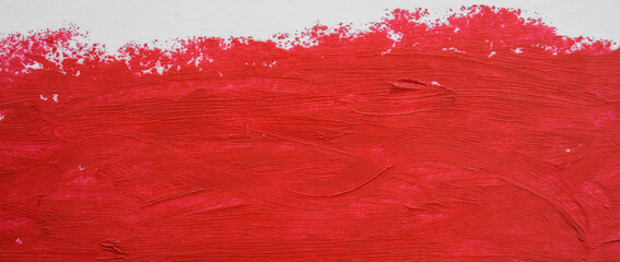 Close-up of a broad horizontal brushstroke of bright red paint on white paper.