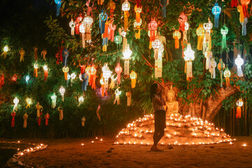 One Asian woman praying before buddha statue inside Wat Phantao (Wat Phan Tao) temple during Loy Krathong festival in Chiang Mai, Thailand