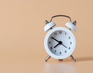 Vintage white alarm clock with two bells on a neutral background, symbolizing time and punctuality
