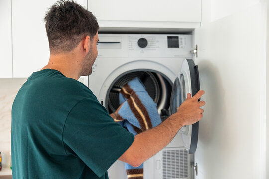 Latin man doing laundry at home daily chore