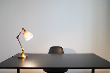 Workplace with Lamp on Dark Desk and Chair in Simple White Room Modern Workspace Interior Design for Studying or Working in Comfortable Minimalist Space