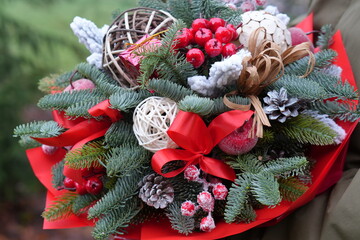 Christmas Floral Arrangement with Fir Branches, Red Ribbons and Holiday Decorations
