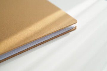 Close Up View of Brown Covered Notebook Revealing Paper Texture and Binding Detail Ideal for Mockups or Design Elements on White Surface