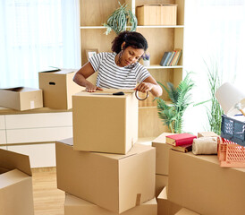 Portrait of ayoung woman girl unpacking boxes after moving in and relocation in a new apartment, or...