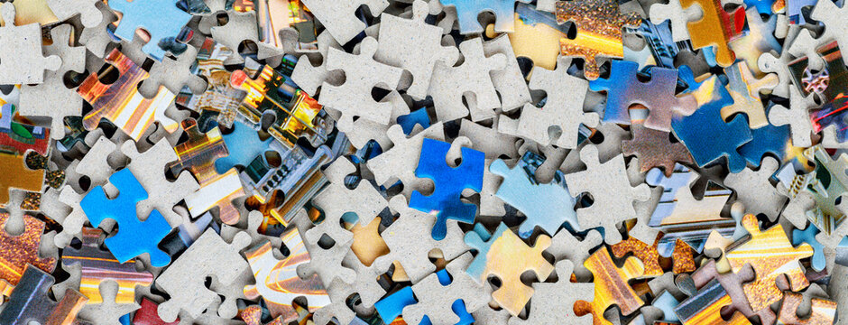 Jigsaw puzzle pieces.Colorful background with small puzzle pieces, messy.Some colored pieces of puzzle as background.Challenge and solution concept. Hobbies and leisure activities