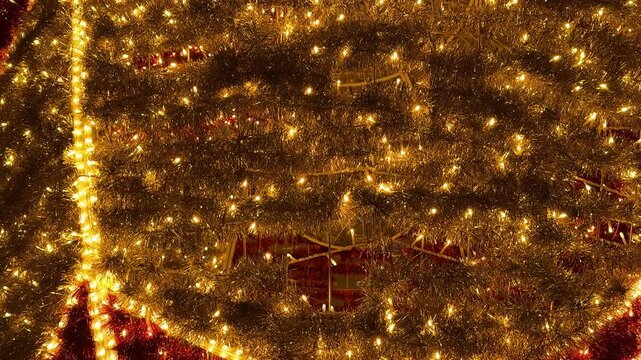 Footage of sparkling christmas tinsels arrangement background, illuminated with twinkle icicle lights. tinsels garland in gold and red colors. Christmas festive decoration. Merry Christmas