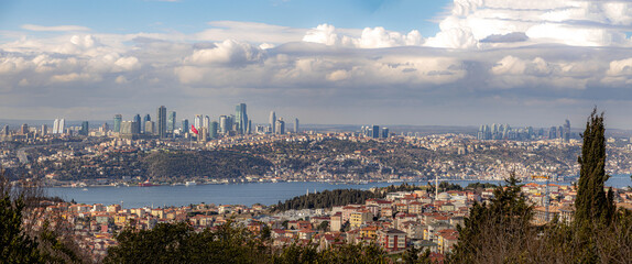 Obraz premium Panoramic view from Camlica Hill over Istanbul, showing both shores of the Bosphorus with houses, parks, and skyscrapers under a sunny sky. Istanbul, Bosphorus, Turkey.