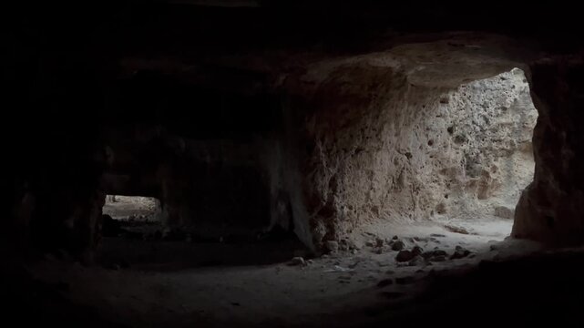 Wide chamber inside Fabrika Hill Cave Complex, soft daylight entering through rough carved openings and illuminating ancient stone surfaces