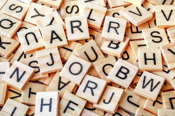 Alphabet letters on wooden block pieces, from above.Close up of Wooden letter cubes.Challenge and solution concept.Hobbies and leisure activities