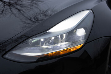 Car front full led matrix IQ Light. Modern car headlamp flashing light with blinking on continuously indicator. Switched on led matrix lights of luxury car. Car Blinker Light.