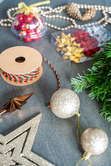 Close-up of a handmade Christmas wreath before decoration, surrounded by various festive ornaments in soft focus. Cozy home preparation for a traditional holiday craft