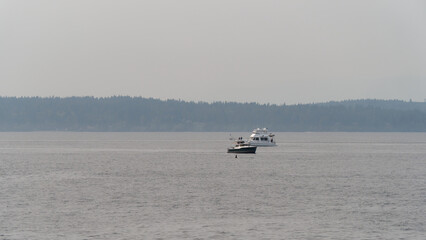 View of a fishing boat on a misty day cruising on the calm waters of Puget Sound near Seattle, Washington, USA