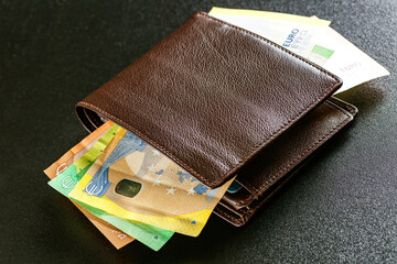 Various currencies in purse close-up.Open wallet with euro banknotes.British coins , pound sterling.Dollars cash and credit cards.Finance concept