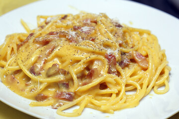 Close-up of creamy Spaghetti Carbonara pasta with bacon and black pepper