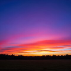 Fototapeta premium Majestic panorama of the evening sky ablaze with color above an open grassy field. Dark tree line silhouettes frame the horizon during twilight, dramatic, expansive, countryside