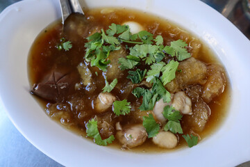 Fish Maw Soup with pieces of chicken meat, egg, and garnished with fresh cilantro in a white oval bowl.