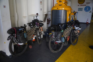 Two touring bicycles inside a ferry during travel adventure