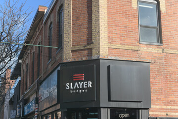 Fototapeta premium exterior building facade and sign of Slayer Burger, a restaurant, located at 739 Queen St E, Toronto