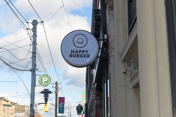 Fototapeta premium round projecting sign outside Happy Burger - 689 Queen St. East, Toronto