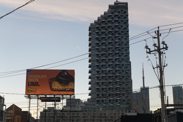Fototapeta premium road side billboard with advertising of Reece candy and a silhouetted view of Monde Condominiums (east elevation), Toronto