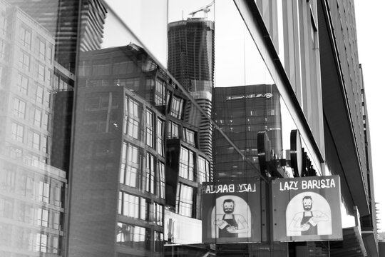 black and white distorted reflection and projecting sign of Lazy Barista, a coffee shop, located at 157 Queens Quay E, Toronto