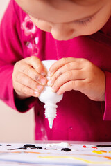 Girl making a creative painting full of bright, mixed colors.