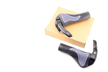 two ergonomic handlebar grips lying on a brown cardboard box