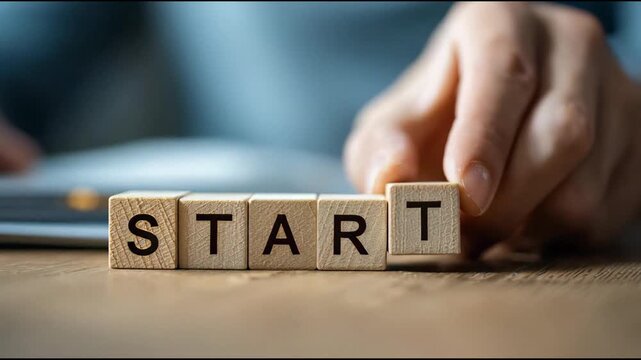 Start wooden block with the hand on office background for new goal and target.
