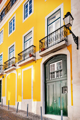 Typical old buildings in Lisbon's lower town, with their windows with balconies, lanterns, and decorative tiles. Lisbon, Portugal, 2023 © Wagner