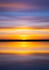 Obraz premium A stunning, tranquil evening landscape at dusk. Brilliant golden hour light colors the vast sky above the dark silhouette of the horizon, tranquility, stunning, vibrant