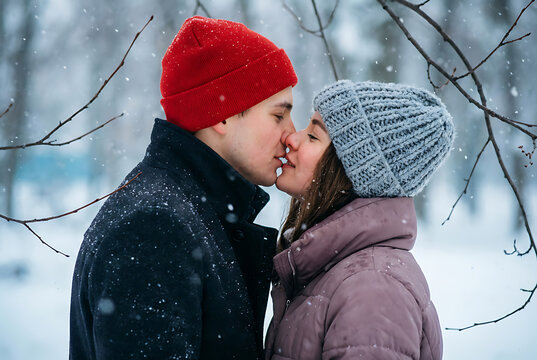 couple in love on a christmas walk in the city, evening snowfall december holiday new year