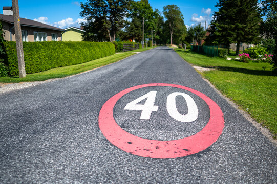 A road sign painted on the road by a countryside street road