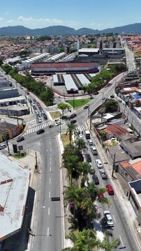 Vis&atilde;o a&eacute;rea de Mogi das Cruzes SP no Alto Tiet&ecirc;, mostrando avenida arborizada, bairros residenciais e com&eacute;rcios sob c&eacute;u claro. Paisagem urbana detalhada ideal para usos editoriais e institucionais
