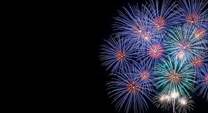 Vibrant blue and green fireworks exploding against a dark night sky with copy space on the left