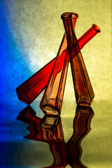 Abstract composition of colored glass bottles on reflective surface
