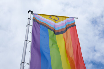 New Progress LGBTQ+ Pride Flag waving in sunlight against blue sky