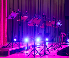 Music stands with sheet music on stage before a concert