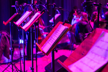 Music stands with sheet music on stage before a concert