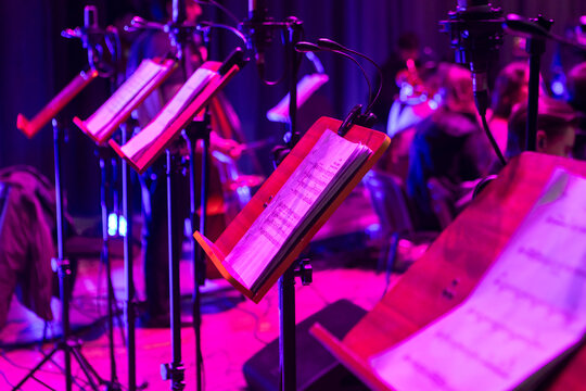 Music stands with sheet music on stage before a concert