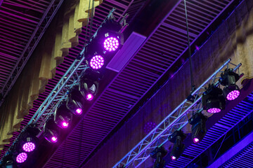 beams of stage lighting illuminate the stage of the hall before the performance