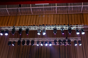 beams of stage lighting illuminate the stage of the hall before the performance