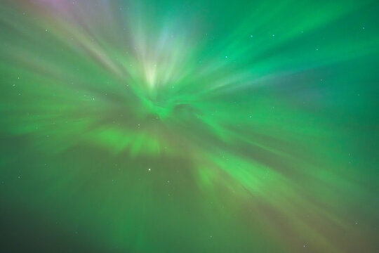 Rare aurora borealis seen in Poland during the strong geomagnetic storm of May 2024. Bright green and pink auroral corona and dynamic rays lighting up the night sky.