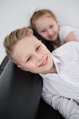 Children enjoying Christmas celebration, laughing in holiday outfits at home