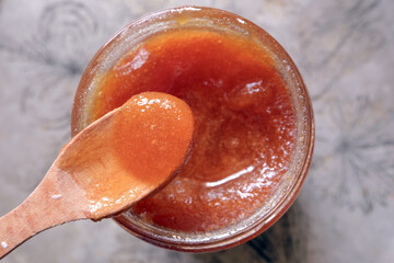 Crystallized natural honey dripping from a wooden spoon.