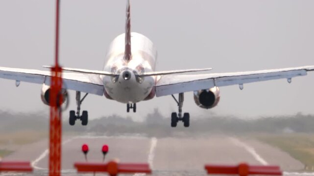 Passenger jet airplane landing and slowing down on the runway. Concept of aviation, air travel, arrival, and modern transportation