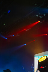 Vibrant concert hall scene featuring vivid red and blue spotlights