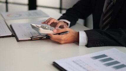 Businessman working in office calculating tax. - Powered by Adobe