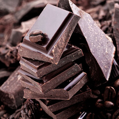 Broken dark chocolate and coffee beans on a wooden table