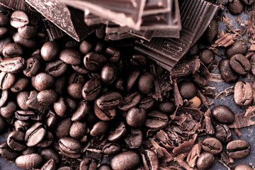 Broken dark chocolate and coffee beans on a wooden table