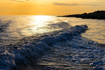 Mediterranean seascape at sunset with roaring onshore waves, scenic coastline horizon, peaceful summer travel vacation background